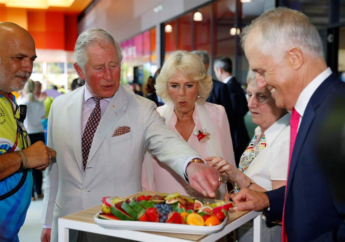 Carlos III y Camilla probando comida 
